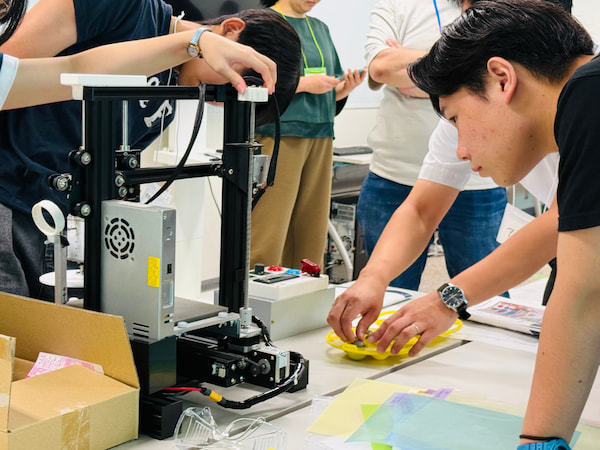 機械が止まった状態でとにかく触りまくり答えを探す参加者達
